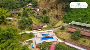 an aerial view of a house with a train at Primavera Ecoalbergue in La Vega