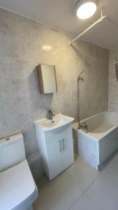 a bathroom with a sink and a bath tub at YO ROOM! Apartments- Next to City Centre Apartment - With Free Parking in Leicester