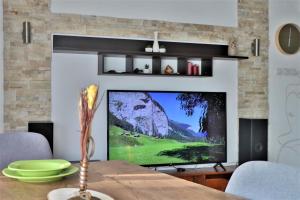 a living room with a flat screen tv and a fireplace at Malda's Apartment in Prishtinë