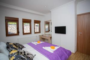 una camera da letto con un letto, asciugamani e una TV di Villa Enjoy XL a Mostar