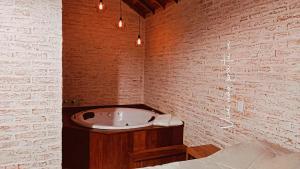 a bathroom with a bath tub in a brick wall at Chalé Villa Magrini in Monte Verde +34 photos
