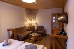 a living room with a couch and a tv at Naturhotel Gasthof Bärenfels in Kurort Altenberg