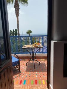 a table on a patio with a view of the ocean at Ryad du Pêcheur Safi in Safi