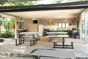un restaurante con mesas de picnic y una cocina en Oasis Tourist Park, en Palmerston