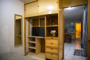 un dormitorio con un centro de entretenimiento con TV y una habitación en Apartamento princesa Rosaura en Morelia