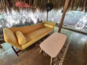 um sofá amarelo num quarto com uma mesa em Magdalena Beach House em Los Naranjos