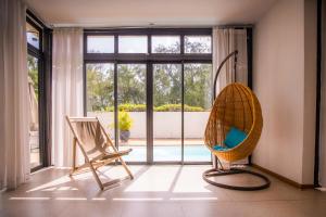 Habitación con 2 sillas y ventana grande. en Villa Simone: Sunlit Beach Getaway w/ Pool + WIFI, en Belle Mare