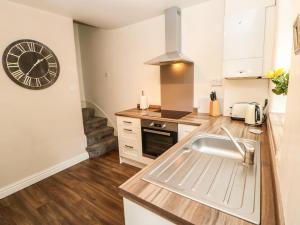 a kitchen with a sink and a clock on the wall at 27 Bongate in Appleby