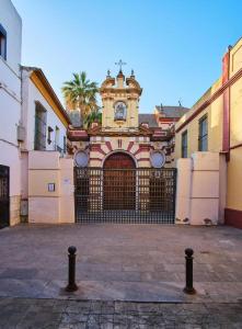 a building with a gate with a clock tower at Reposo Sweet Home & Free Parking in Seville