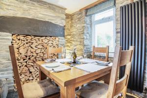 uma sala de jantar com uma mesa de madeira e uma parede de pedra em Garreg Ddu em Blaenau-Ffestiniog