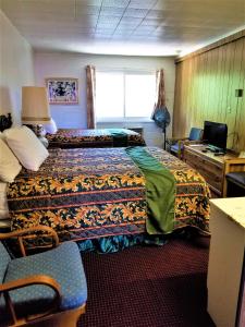 Habitación de hotel con cama, escritorio y ventana en Town House Motor Inn en Worland