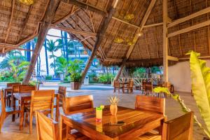 a restaurant with wooden tables and chairs in a resort at Las Palmas by the Sea All Inclusive in Puerto Vallarta