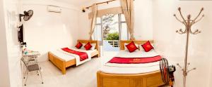 een slaapkamer met 2 bedden en een raam bij NHÀ NGHỈ PHƯƠNG THẢO in Quan Lạn