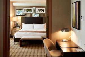 a hotel room with a large bed and a chair at Loden Vancouver in Vancouver