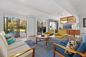 a living room with a couch and chairs at Sputnik Beach House by Experience Jervis Bay in Vincentia