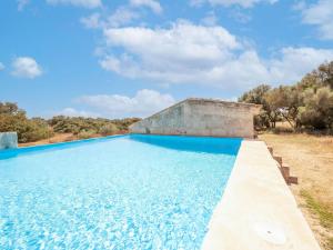 カンポスにあるDuplex on estate with private access to the most beautiful beach in Mallorcaの青い水と木々を背景にしたスイミングプール
