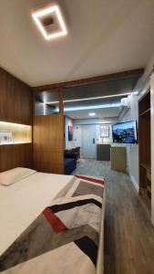 ein Schlafzimmer mit einem großen Bett und einem Flachbild-TV in der Unterkunft Costa Sul Beach Hotel in Balneário Camboriú