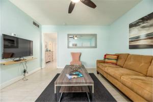 ein Wohnzimmer mit einem Sofa und einem Tisch in der Unterkunft Steps to Sand and Sea 2 in Fort Lauderdale