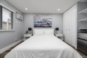 a bedroom with a large white bed with two tables at Shell on the Beach 103 - RENOVATED in Hollywood