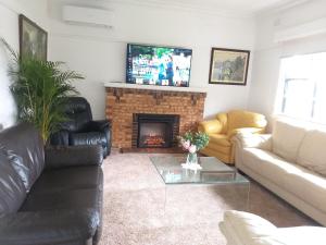 sala de estar con sofá y chimenea en Peaceful Home en Bendigo