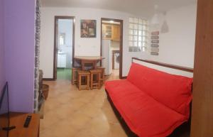 a living room with a red couch and a table at Casinha da Peneda in Góis