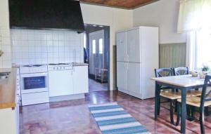 a kitchen with white appliances and a table with chairs at Holiday Home Möllstorpsgatan Färjestaden in Färjestaden +6 photos