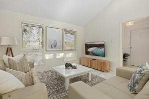 a living room with a couch and a table at Rock Salt by Experience Jervis Bay in Huskisson