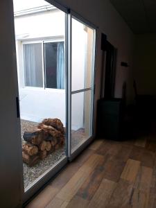 una puerta corredera de cristal con una pila de troncos en Las Calandrias en Villa Constitución