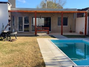 a house with a pool and a picnic table and a barbecue at Las Calandrias in Villa Constitución