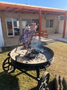 a bbq grill with meat on it in a yard at Las Calandrias in Villa Constitución