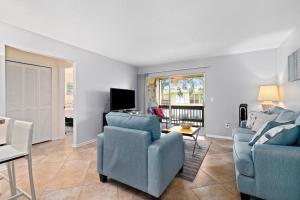 ein Wohnzimmer mit 2 blauen Stühlen und einem TV in der Unterkunft Shell house retreat in Sarasota