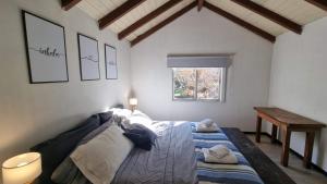 1 dormitorio con cama, mesa y ventana en Caballería de los Andes - Andarlibre en San Martín de los Andes