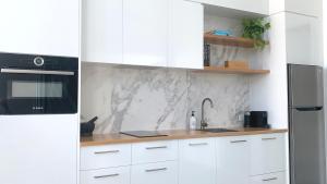 a white kitchen with a sink and a refrigerator at Bellbry Lodge in Trinity Beach