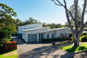 a white house with a driveway at The Oasis of Calm by Experience Jervis Bay in Huskisson