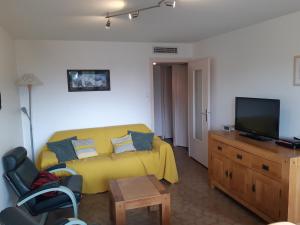 - une chambre avec un lit jaune et une télévision dans l'établissement Appartement Les Deux Alpes, 3 pièces, 6 personnes - FR-1-516-181, à Les Deux Alpes