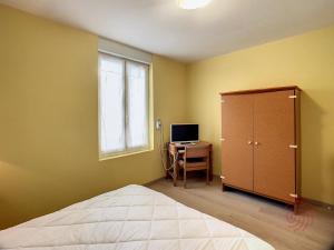 a bedroom with a bed and a desk and a window at Charmant F2 climatisé avec terrasse, proche Thermes, parking privé, animaux acceptés - FR-1-451-163 in Lamalou-les-Bains