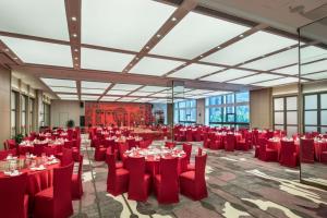 a large banquet hall with red tables and chairs at Ramada by Wyndham Baoji Jintai in Baoji