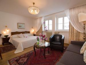 a bedroom with a bed and a chair and a table at Austria Classic Hotel Wolfinger - Hauptplatz in Linz