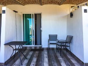 zwei Stühle und ein Tisch auf der Veranda eines Hauses in der Unterkunft Casa Bravía - Hotel·RV in San Luis Soyatlán