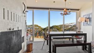 a dining room with a table and a large window at Lawlers 6 in Mount Hotham