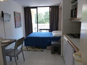 ein kleines Zimmer mit einem Bett und einem Tisch sowie einer Küche in der Unterkunft Studio Le Lavandou, 1 pièce, 4 personnes - FR-1-308-152 in Le Lavandou