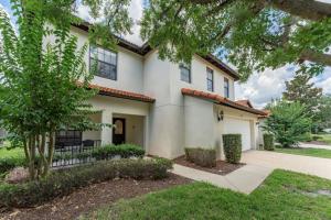 a white house with a gate and trees at Romantic forest view Villa w pool near Disney in Kissimmee