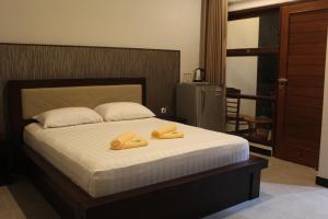 a bedroom with a bed with two yellow slippers on it at New ASTA GRAHA GUESTHOUSE in Jimbaran