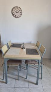 a dining room table with chairs and a clock on the wall at Seaside appartment to enjoy,relax with great view in Gázion