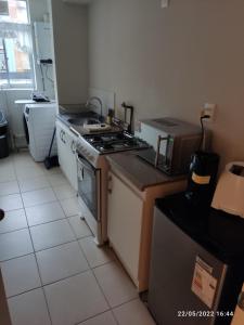 a kitchen with a stove and a counter top at Departamentos amoblados - Santa Sofia. in Concepción