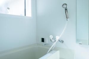 a shower in a bathroom next to a window at Shiki Homes HIKARI in Kyoto