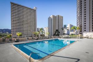 a swimming pool on the roof of a building with tall buildings at Aston at the Waikiki Banyan in Honolulu