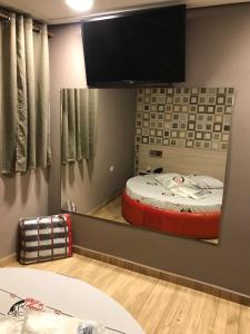 espejo en una habitación con cama y TV en Hotel Moinho do Leste, en São Paulo