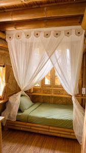 a bed in a room with a mosquito net at Elang Hillside Bamboo Villas in Labuan Bajo