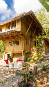 a large wooden house with couches in front of it at Elang Hillside Bamboo Villas in Labuan Bajo